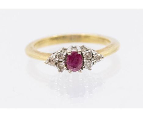 A ruby and diamond set 18ct gold ring, comprising an oval cut ruby to the centre, a trio of round brilliant cut claw set diam