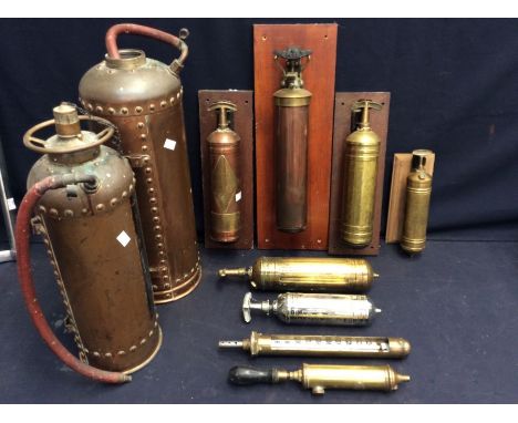 A collection of vintage copper fire extinguishers - both floor standing and wall fixing.