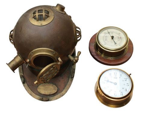 A decorative brass and copper U.S Navy diving helmet along with ships barometer and a ships clock.