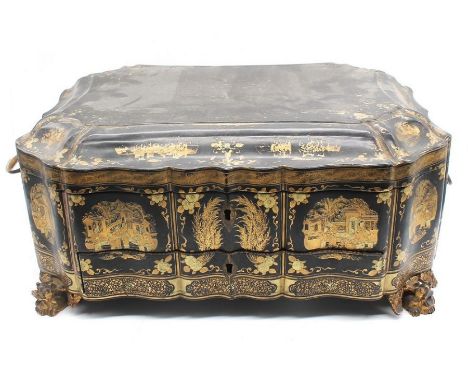 An early 20th century Chinese black lacquered trinket box with gilt detail and Chinese scene decoration, standing on Dragon h