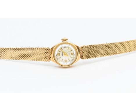 A ladies vintage 9ct gold Smiths wrist watch, comprising a round silvered dial, applied gilt baton markers and numbers, case 