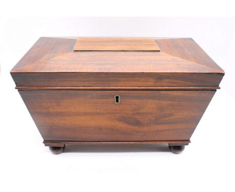 A mid-19th century mahogany sarcophagus-shaped tea caddy with two internal compartments - mixing glass is missing.