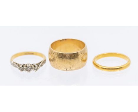 Three gold rings to include a diamond set 18ct gold three stone ring, size K, total gross weight approx 2.3gms along with a n