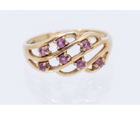 A ruby and 9ct gold ring, comprising an open work wire form claw set with small round mixed cut rubies, width approx 8mm, siz