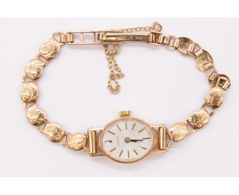 A ladies 9ct gold vintage Tissot wristwatch, comprising a silvered oval dial with applied baton markers, case approx 14mm, to