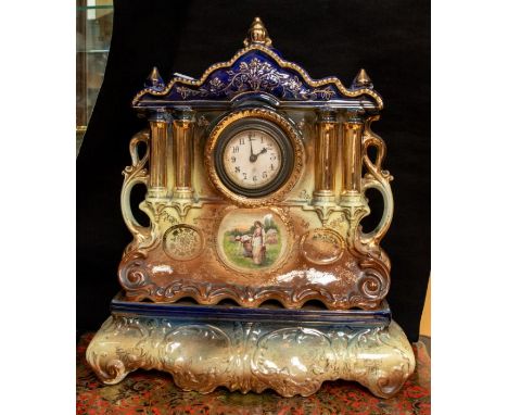 A large Edwardian ceramic mantel clock on a stand.
