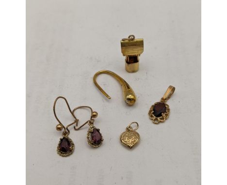 Mixed 9ct gold items comprising of a charm fashioned as a well, garnet set pendant and earrings 3g, a plated pendant and a ri