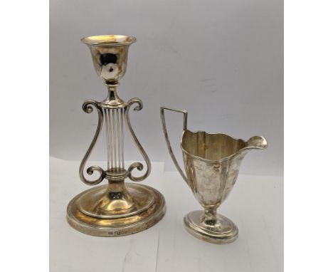 A silver candle stick holder weighted hallmarked London 1902, together with a silver jug 113.1gLocation: 