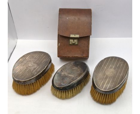 Three silver dressing table brushes to include a pair having engine engraved detail and one in a brown leather caseLocation: 