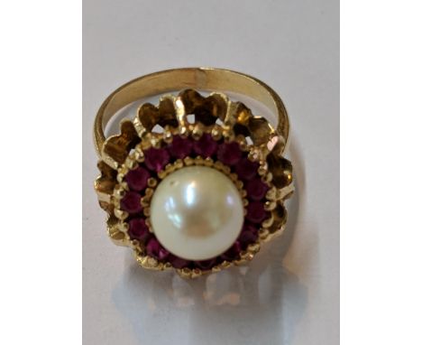 A yellow metal pearl ring surrounded by red coloured stones, tested as 14ct, 5.9gLocation: 