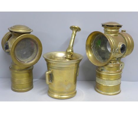A brass pestle and mortar and two vintage cycle lamps 