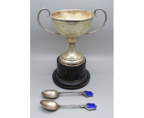 A silver trophy and a pair of silver and enamel golf spoons, (total weight 155g including the metal mount in the base of the 