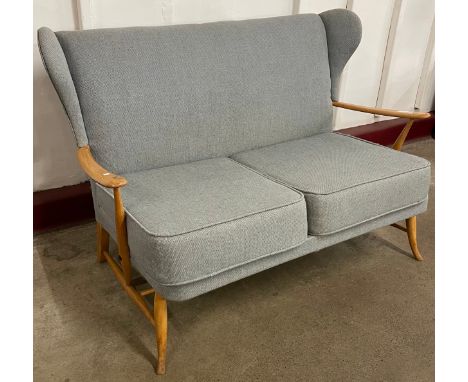 An Ercol Blonde beech and blue fabric upholstered Windsor settee 