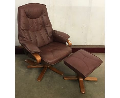 A beech and red leather revolving lounge chair and footstool 