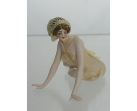 1920's German Bisque Bathing Beauty, depicted seated with legs curled beneath her, leaning forward with arms outstretched, co
