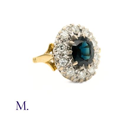 The 18ct yellow and white gold ring is set with an oval cut blue sapphire weighing approximately 1.9ct with round cut diamond