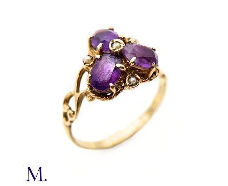 The 9ct yellow gold ring is set with three amethysts in trefoil design with a small pearl centre. The band is marked for 9ct 