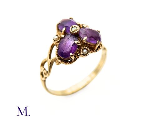 The 9ct yellow gold ring is set with three amethysts in trefoil design with a small pearl centre. The band is marked for 9ct 