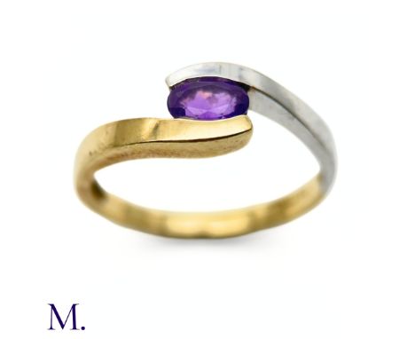 The two colour gold ring is set with an oval-cut amethyst. The band is unmarked but tests indicate 9ct gold.Box not included;