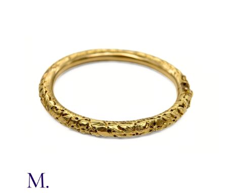 The French 18ct yellow gold bangle dates from the Art Nouveau period is smooth to the inside and engraved with texture and pi