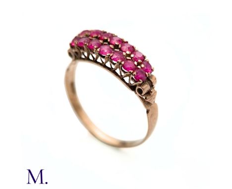 The antique rose gold ring with pierced gallery is set with two rows of seven round cut rubies. The ring is not hallmarked bu