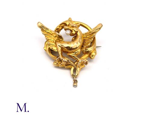 The 18ct yellow gold brooch depicts a mythical chimera in flight with a pearl in its mouth and a further pearl set in a drop.