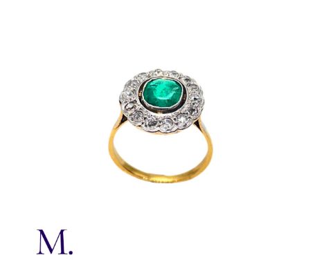 The 18ct yellow and white gold ring is set with a good colour emerald of approximately 0.50ct together with fourteen old cut 