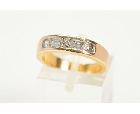 A DIAMOND RING, designed with three princess cut diamonds and four baguette cut diamonds within a rub over setting on a plain