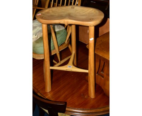 A LIGHT OAK AND ASH TOPPED BAR STOOL, with a carved dish top on triple legs united by a stretcher