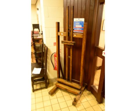 A LATE VICTORIAN OAK STUDIO EASEL, duel iron crank system, stamped 35, on four ceramic casters, the front right with screw he
