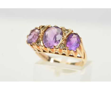 A 9CT GOLD AMETHYST AND DIAMOND RING, designed as three graduated oval amethysts interspaced by four brilliant cut diamonds, 