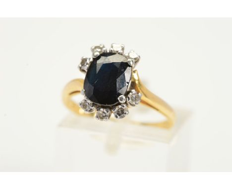 AN 18CT GOLD SAPPHIRE AND DIAMOND RING, designed with a central oval sapphire with an off centre row of four single cut diamo