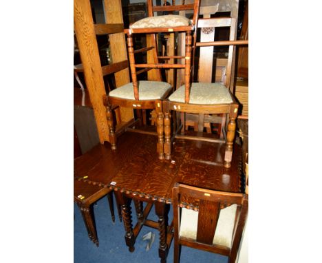 AN OAK BARLEY TWIST GATE LEG TABLE, with pie crust edging, together with four oak chairs, a mahogany nest of three tables and