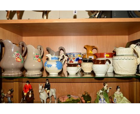ELEVEN VICTORIAN POTTERY AND PARIAN JUGS AND A COPY OF 'RELIEF MOULDED JUGS 1820-1900' by R K Henry Wood, the jugs to include