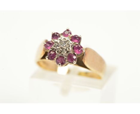 A 9CT GOLD DIAMOND AND GARNET RING, a tiered design with a central single cut diamond in an illusion setting with a circular 