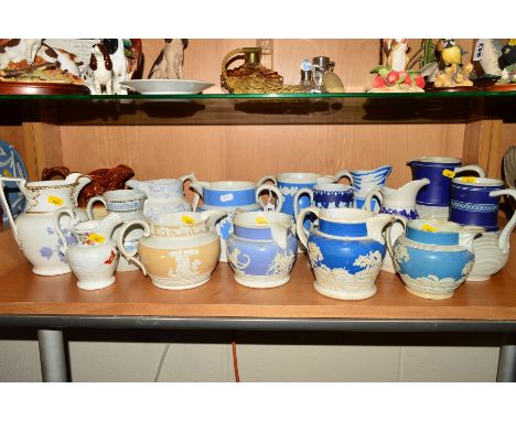 SIXTEEN VICTORIAN STONEWARE AND PORCELAIN JUGS, the majority relief moulded with hunting scenes, classical scenes, turned des