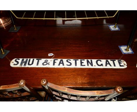 A VINTAGE CAST IRON BLACK AND WHITE GROUND GATE SIGN, reading Shut &amp; Fasten Gate