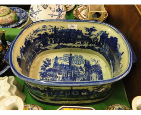 A blue & white ceramic footbath with printed continental scenes