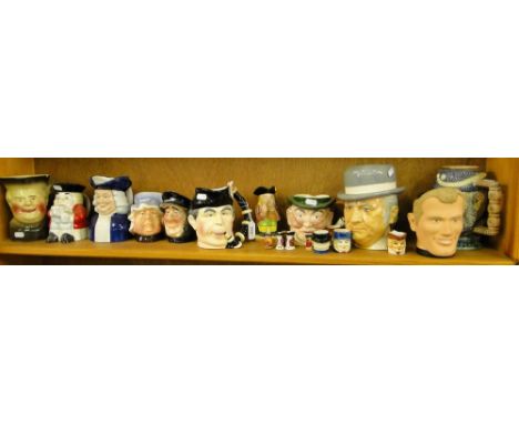 A shelf of various character jugs, including Dickens characters