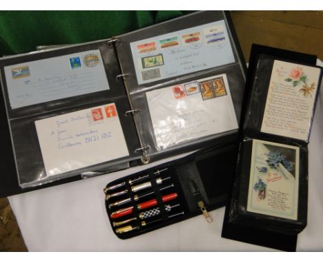 An album of first day covers, postcards & a pen set