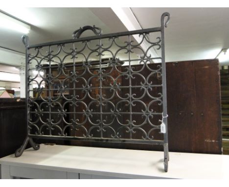 A Pierced scrolled metal fire screen