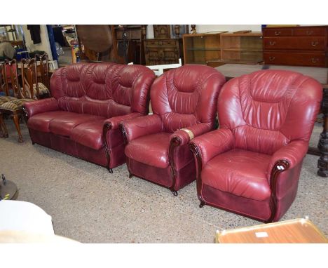 A red leather three seater sofa and matching armchair