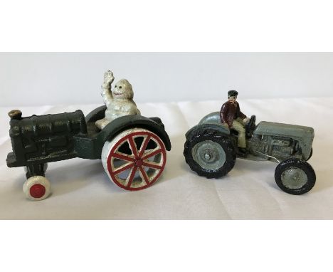 2 cast iron tractor figurines. Michelin Man seated on a Fordson together with Harry Ferguson seated on a Ferguson. 