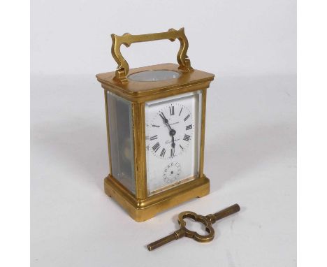 An early 20th century lacquered brass carriage clock, having a white enamel dial signed Simmons of Cheltenham, Roman numeral 