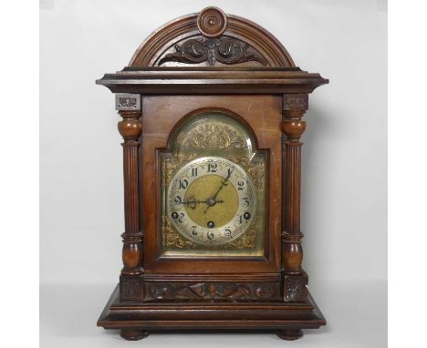 A late 19th century continental walnut cased mantel clock, the brass dial showing arabic numerals, having an eight day moveme