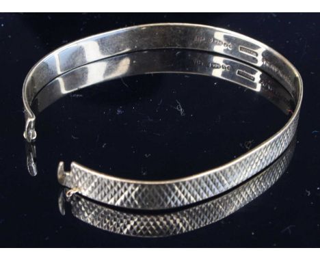 A 9ct gold and engine turned expanding bangle, sponsor NYMPH, dia. 6.4cm, 13.4gWidth 0.7cm.  The bangle is undamaged as in cr