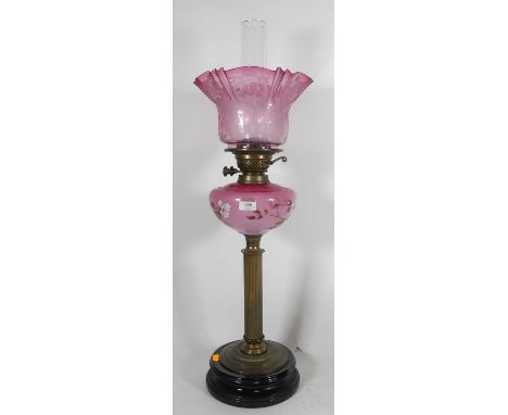 A Victorian oil lamp with cranberry acid etched shade and painted oil reservoir on ionic columnShade opening dia 9.75cm, some