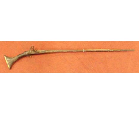 A Middle Eastern Jezil Matchlock long arm rifle together with a small bamboo arrow.