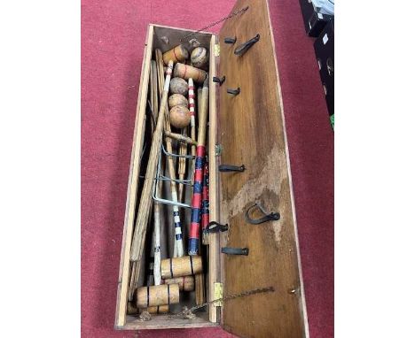 A wooden cased croquet set with indistinct writing to top