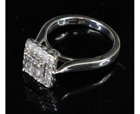 An Art Deco style white gold and diamond tablet ring, centre bezel set with four princess cuts in a surround of 16 small roun